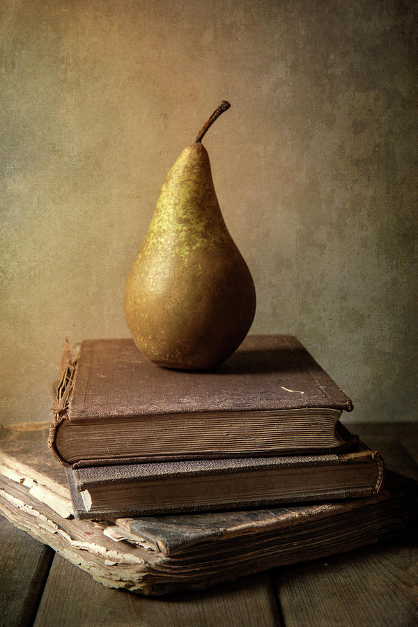 A pear resting on a stack of old books — representing the PEARS study method